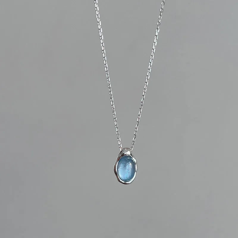 Geometric navy blue water drop pendant necklace on an adjustable copper chain.