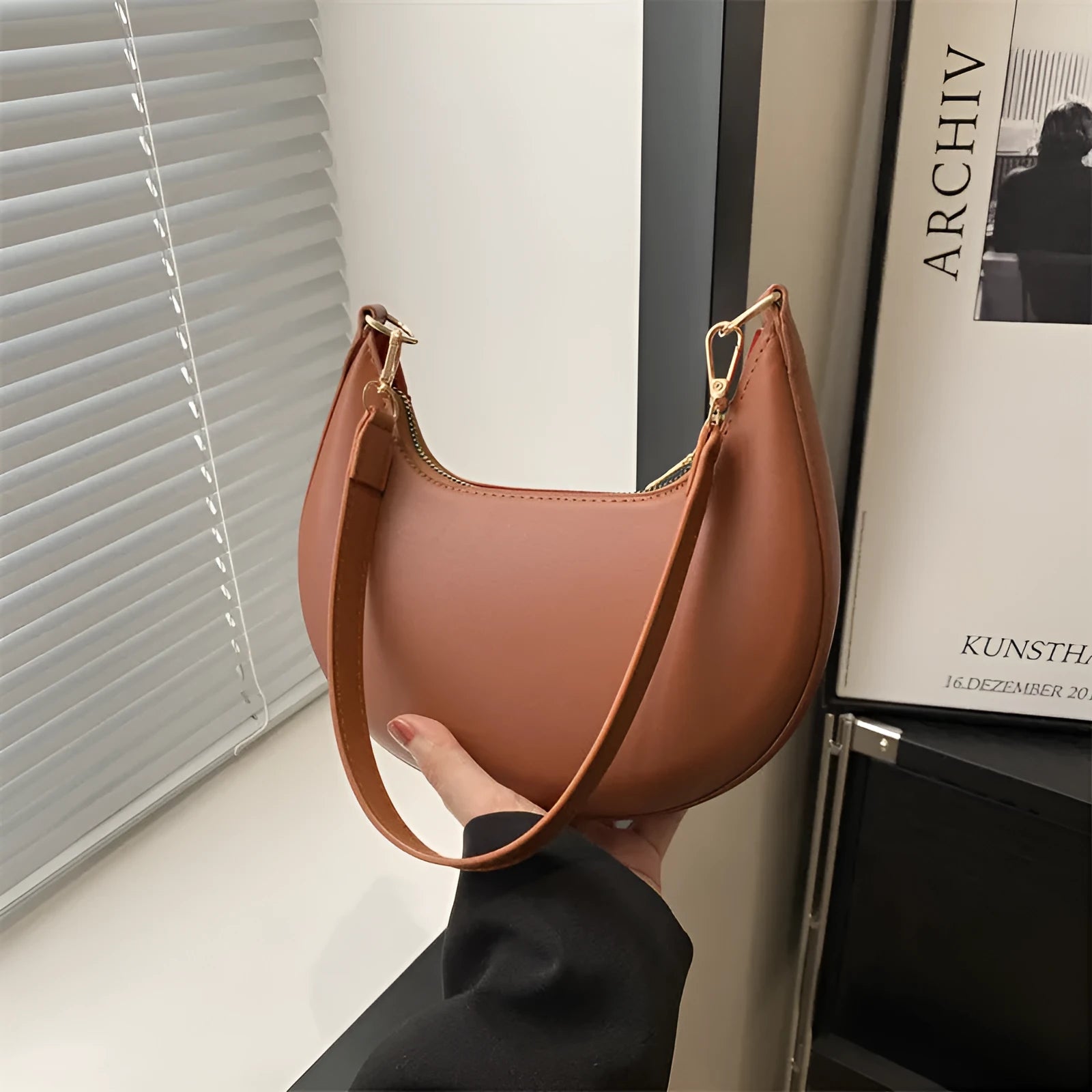Round green one-shoulder underarm bag showing sewing line detailing and sandwich pocket design