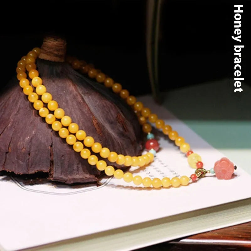 Yellow chicken grease beeswax amber bracelet with 5mm round beads and animal zodiac design.