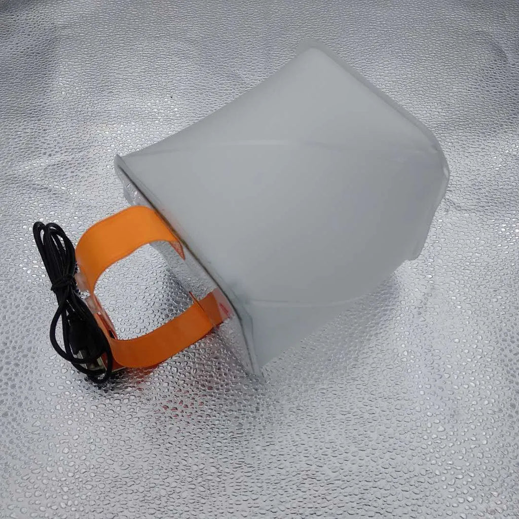 White solar inflatable waterproof camping LED lantern with handle, collapsed flat on a table