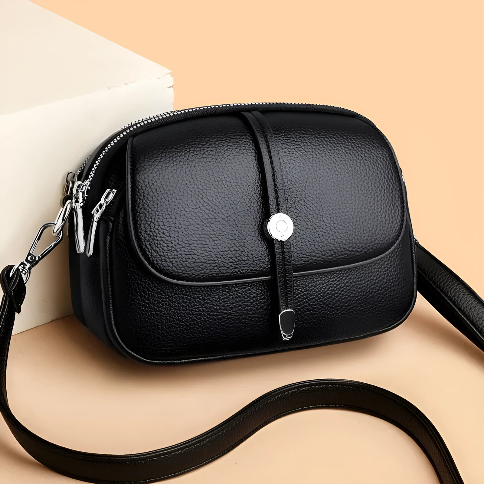 Women's oval crossbody shoulder bag in black, khaki or dark brown with visible sewing thread detail