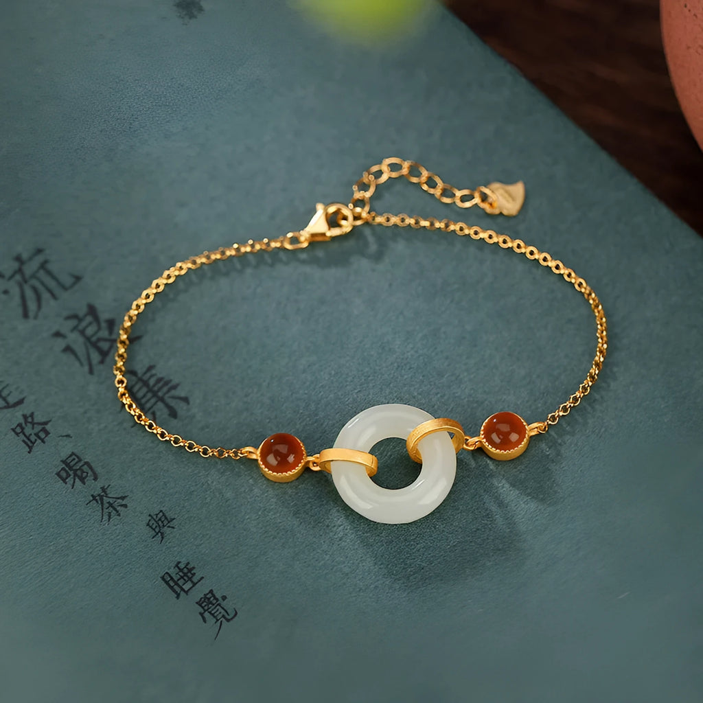 Gold-coloured women's bracelet with a silver and jade peace buckle on an adjustable chain.