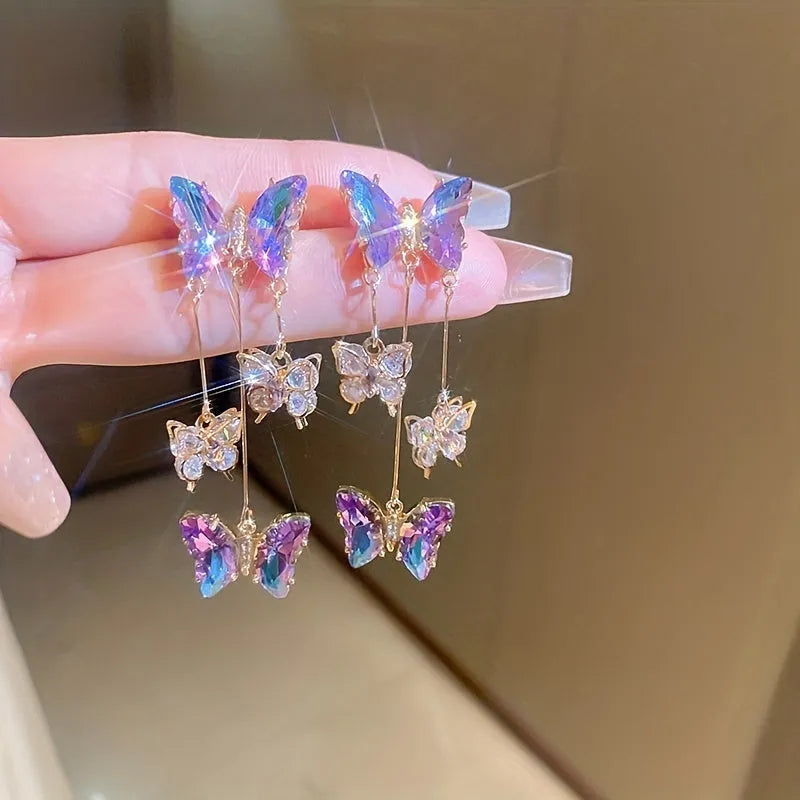 A pair of blue purple butterfly tassel earrings with silver needle crystal flowers on alloy posts.