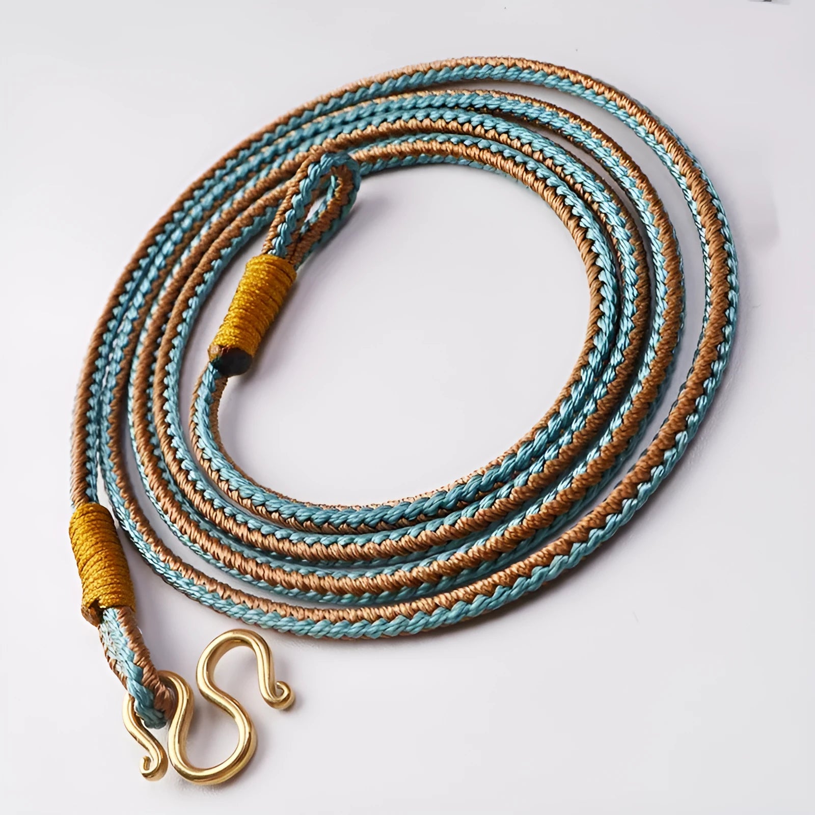 Gold and silver adjustable imitation pearl peace buckle with mixed gemstone inlaid pendant on a wrist.
