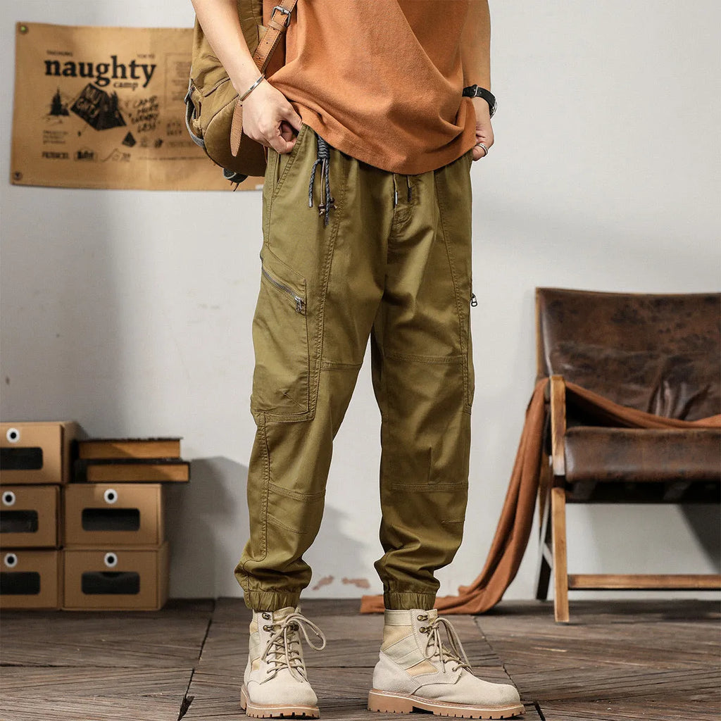 Men's khaki cotton harem pants with tapered leg and ankle band on a mannequin.