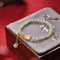 Jade women's bracelet with gold-plated gourd charm and fu character traditional design elements