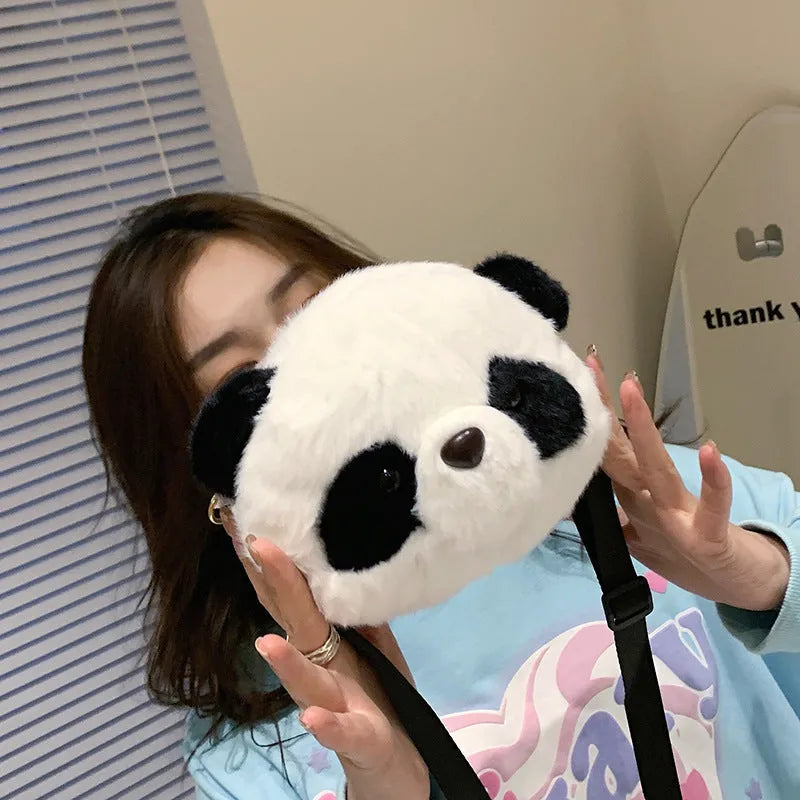 Soft plush panda head crossbody bag with cylindrical shape and outer pocket.