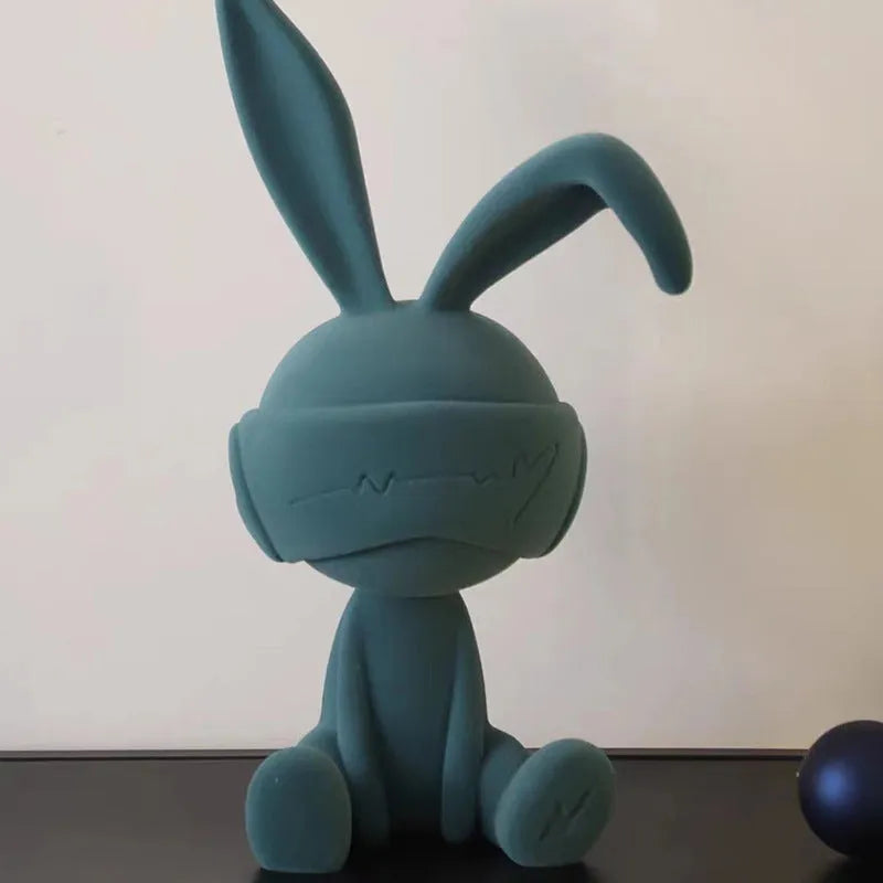 Green suede blindfold rabbit resin ornament seated on a table