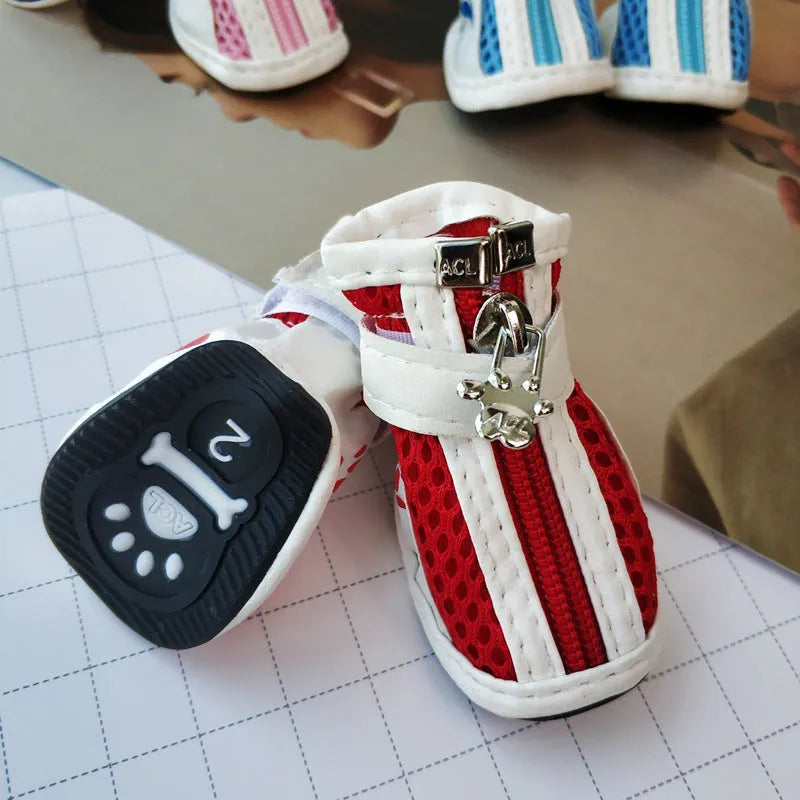Four blue cloth dog sneakers with zipper closures arranged on a white background