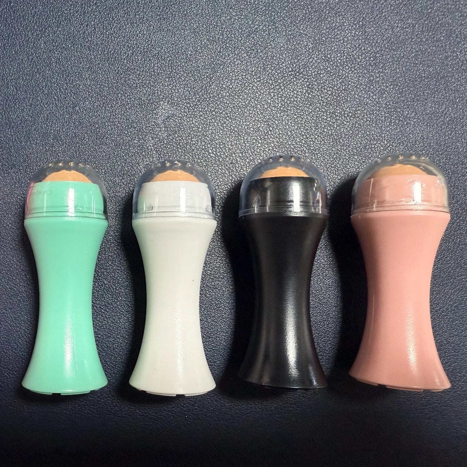 Portable volcanic stone facial roller for oily skin control in choice of colours.