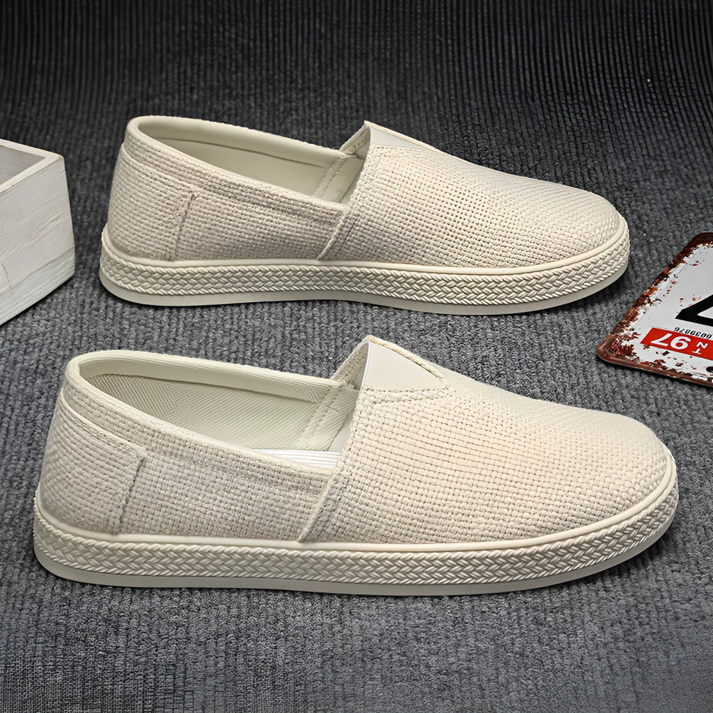 Men's beige linen cloth shoes with canvas upper and PVC sole on a plain background.