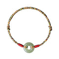 A woven bracelet with a peace buckle on a colourful braided rope.