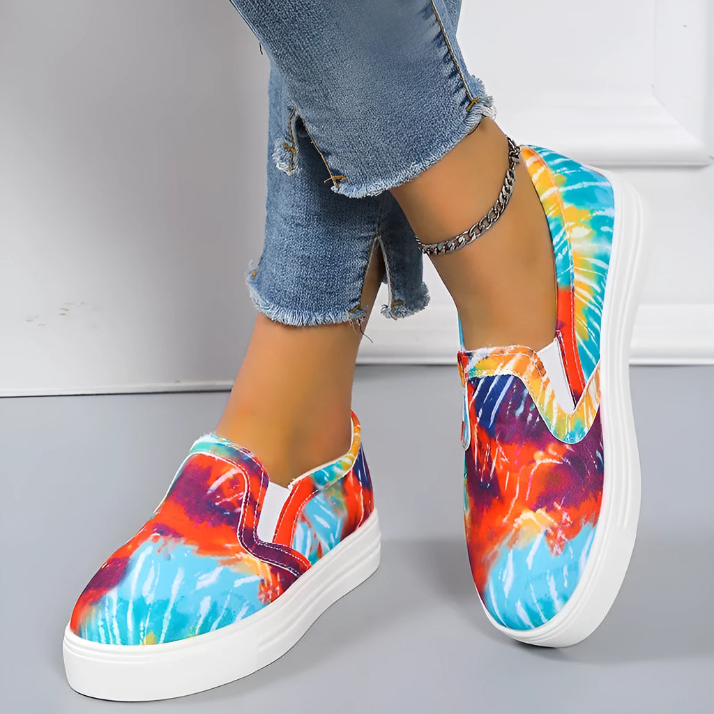 Women's low-top canvas slip-on sneaker in multiple colours, showing flat rubber sole and slip-on design.