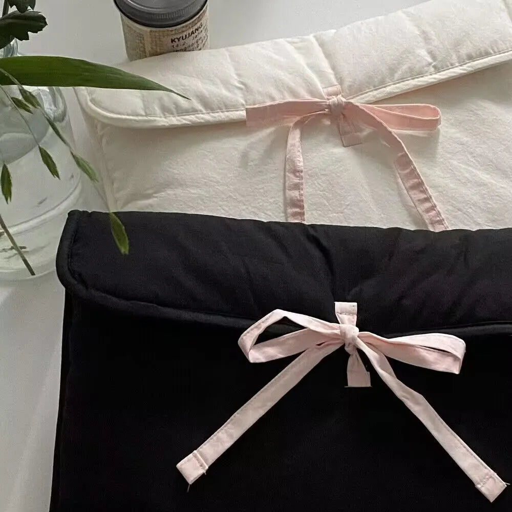 Black and white quilted women's laptop bag with a large decorative ballet bow on the front.