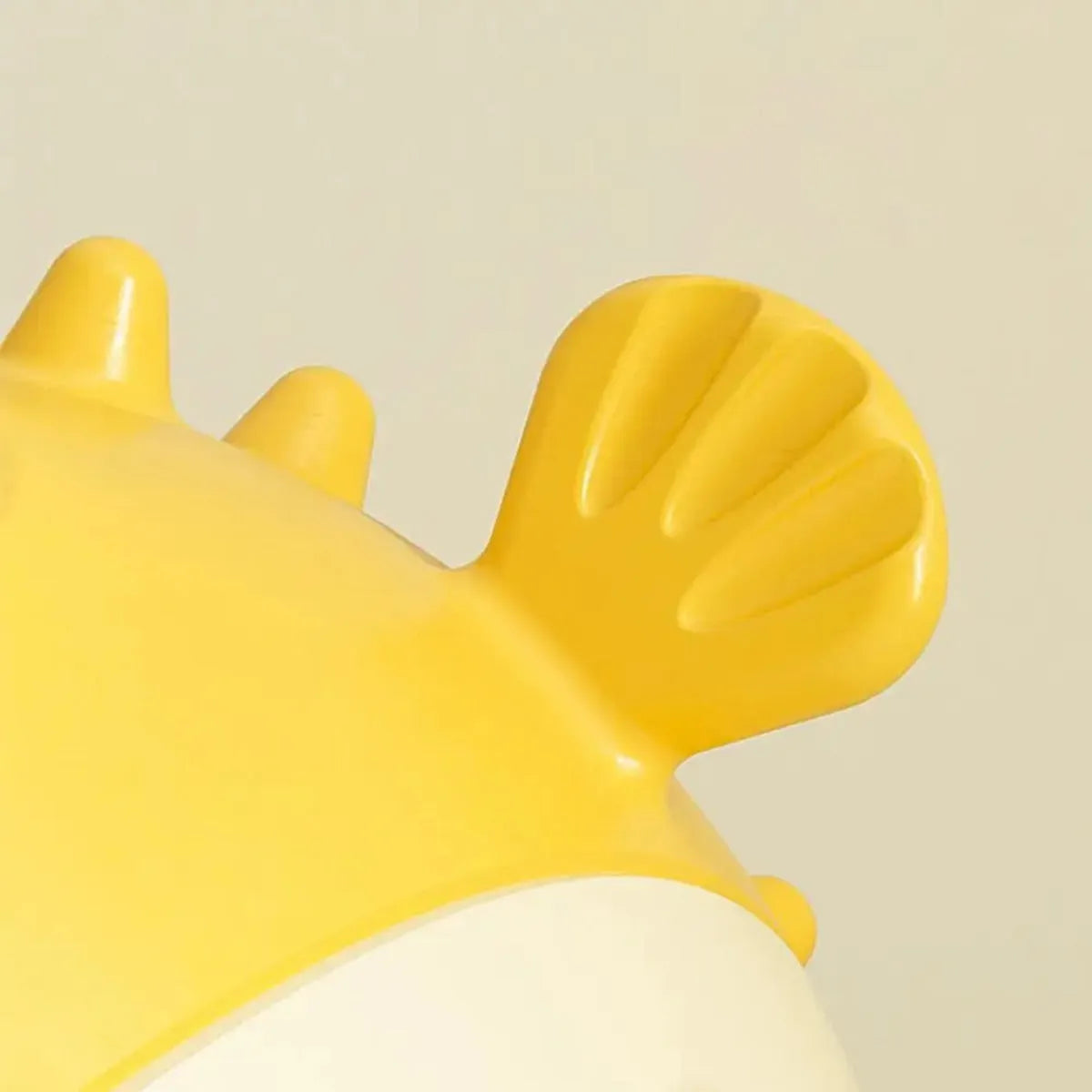 Yellow vinyl fish-shaped dog chew toy with textured surface for teeth cleaning.