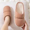 A pair of thick-soled down cotton slippers for men and women in a choice of colours, featuring a non-slip rubber sole.
