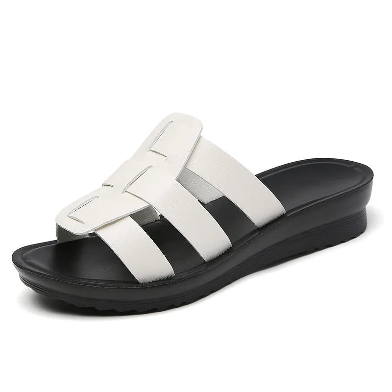 Beige women's flat bottom slippers with waxed leather upper and non-slip sole.