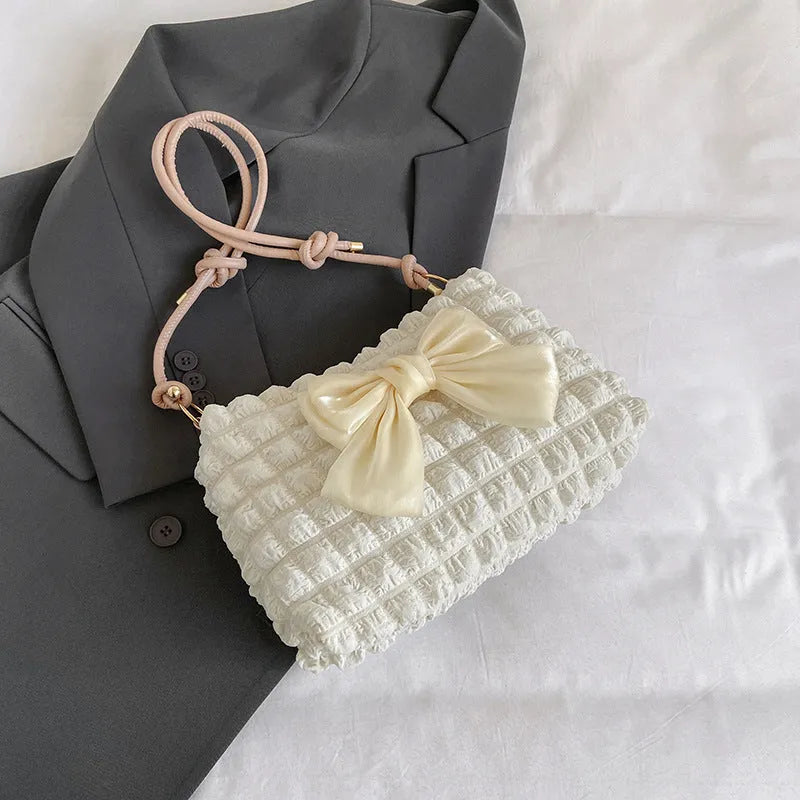 Street style canvas one-shoulder handbag in horizontal square shape with visible stitching.