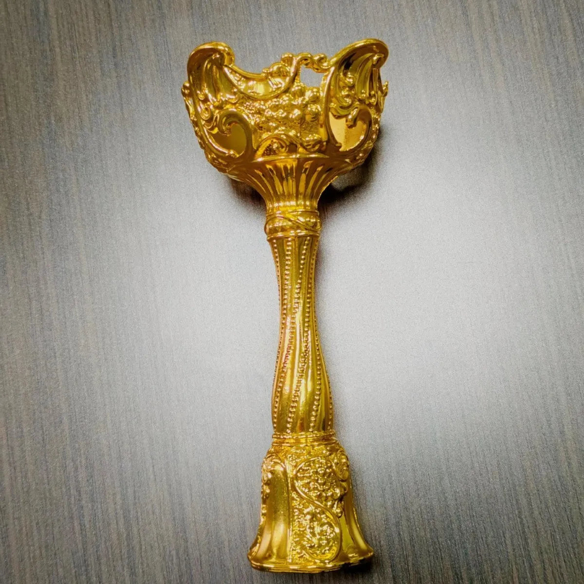 Small metal retro candlestick ornament in gold finish on a table