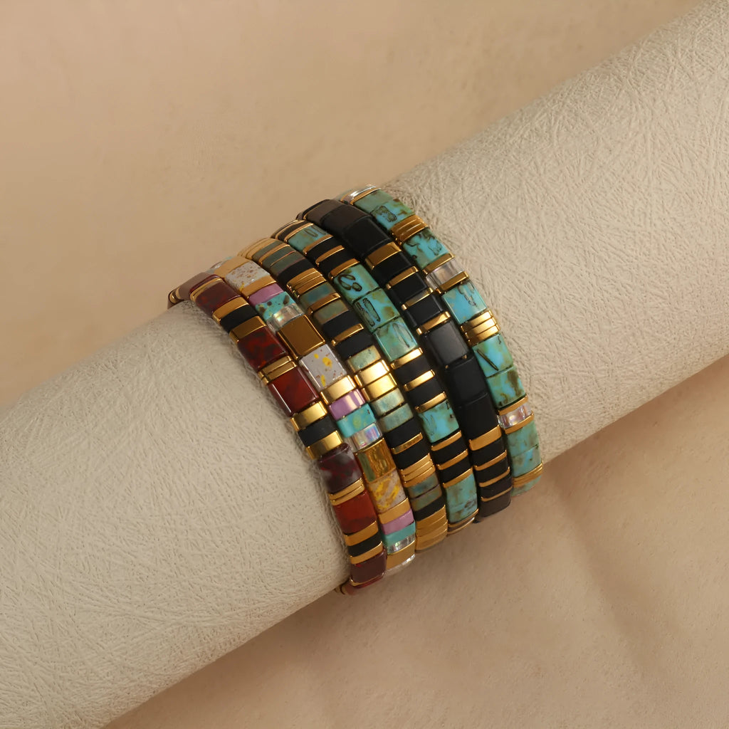 Geometric round glass bead bracelet in five colour options on a wrist.