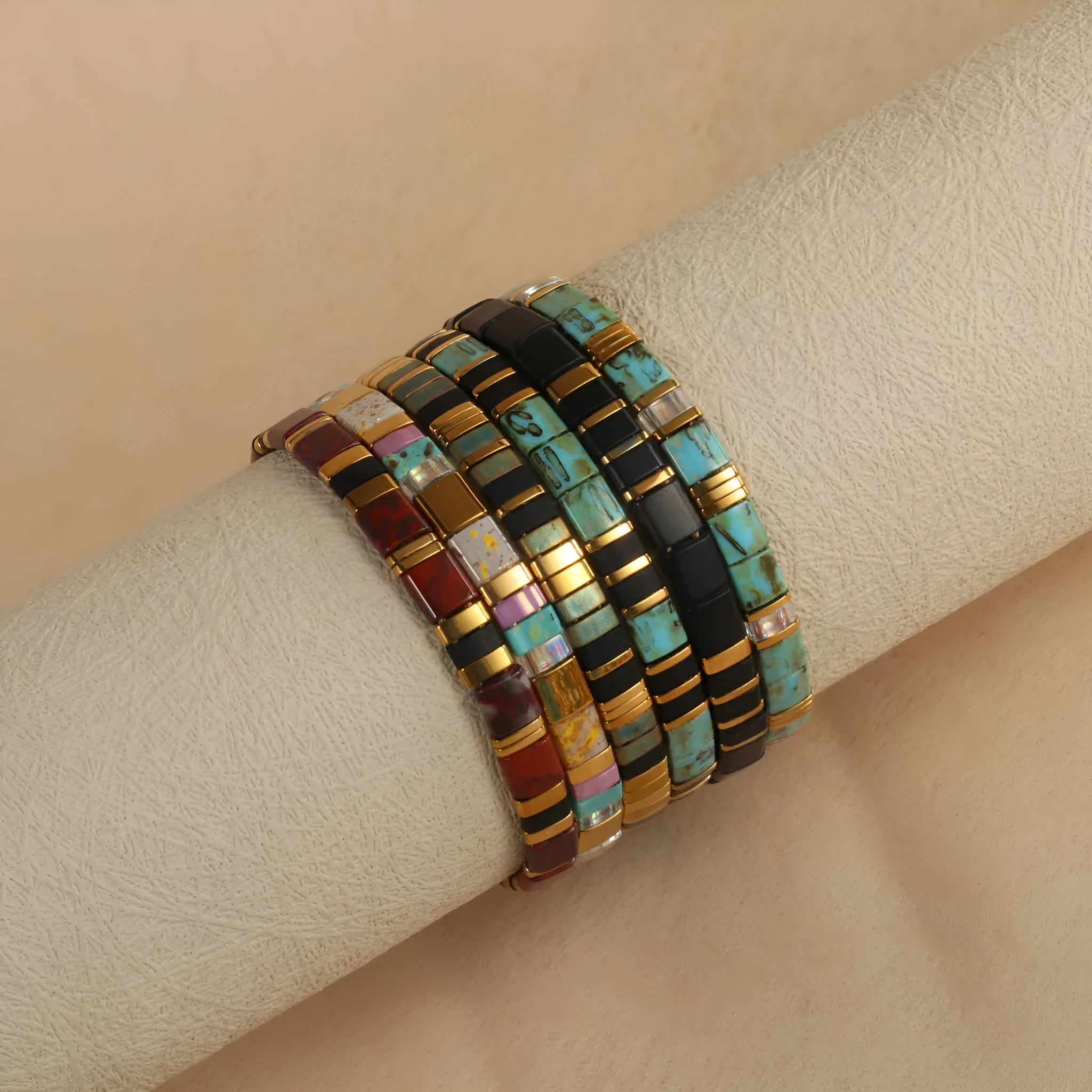 Geometric round glass bead bracelet in five colour options on a wrist.