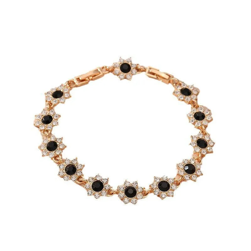 Electroplated zinc alloy flower bracelet with coloured crystals in gold or silver finish.