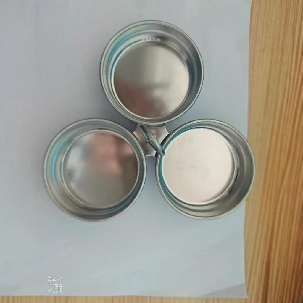 Mini stainless steel egg steamer in heart-shaped and round designs on a kitchen counter.