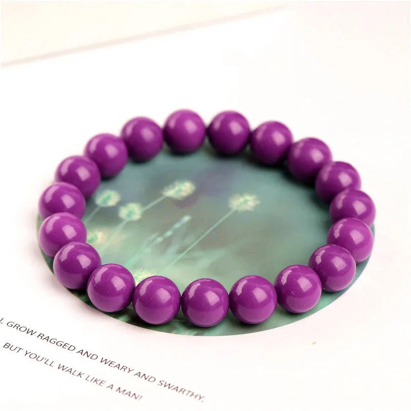 Close-up of a polished purple mica crystal bracelet with a single ring of beads on a wrist.
