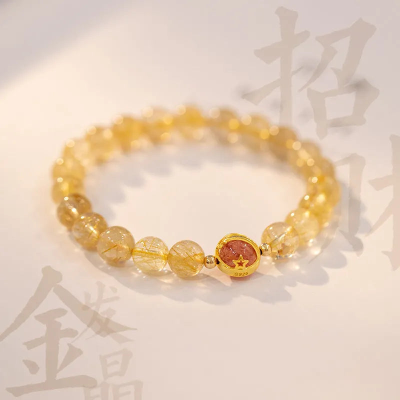Citrine and gold rutilated quartz bracelet with diamond-cut beads in 6mm or 8mm size on a wrist.