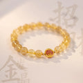 Citrine and gold rutilated quartz bracelet with diamond-cut beads in 6mm or 8mm size on a wrist.