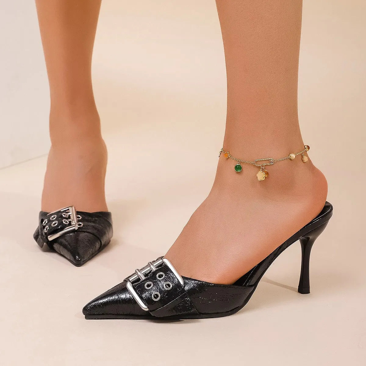 Black women's high heels with decorative buckle on ankle strap and pointed toe design