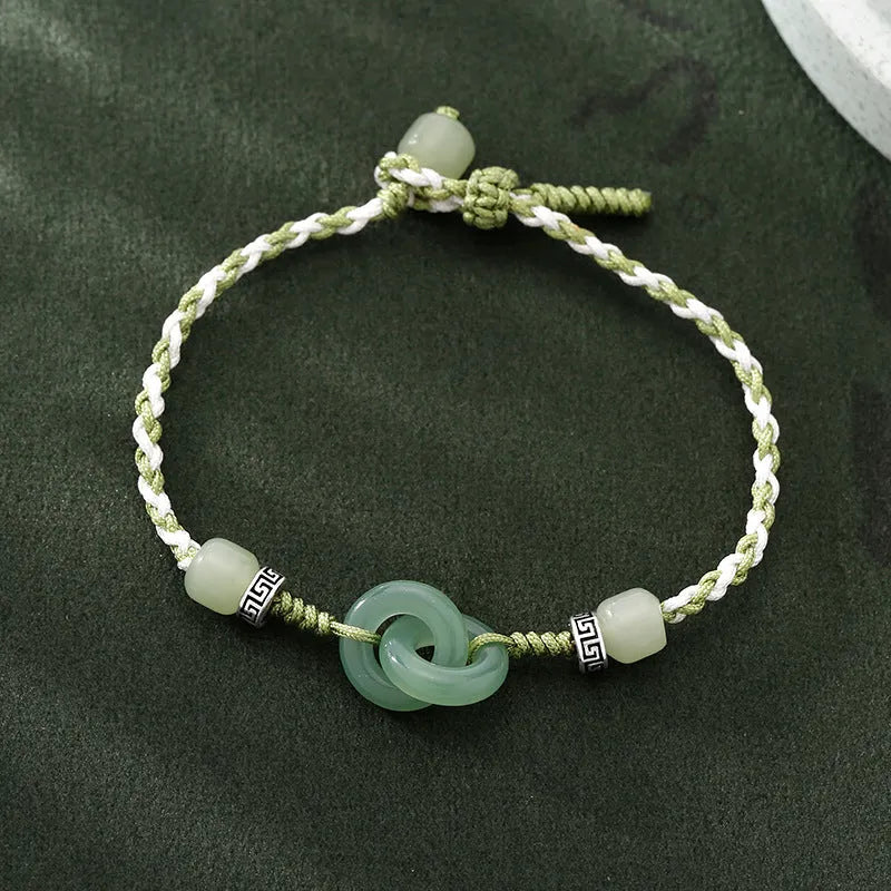 Green adjustable bracelet with jade peace buckle and copper zodiac charm.