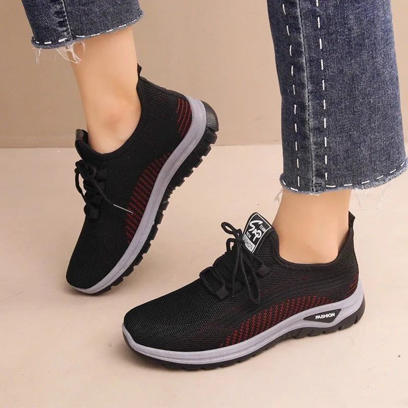 Women's low-top mesh sneakers in black, gray, or purple with round toe, cross straps, and rubber sole.