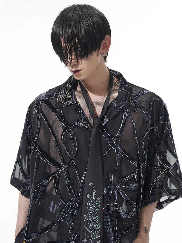 Man wearing a black and grey snake pattern short-sleeved translucent polyester shirt with a loose fit.