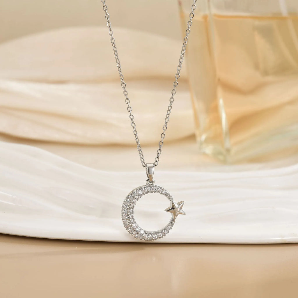 Xingyue gold geometric moon pendant necklace with zircon stone on titanium steel O-ring chain against white background