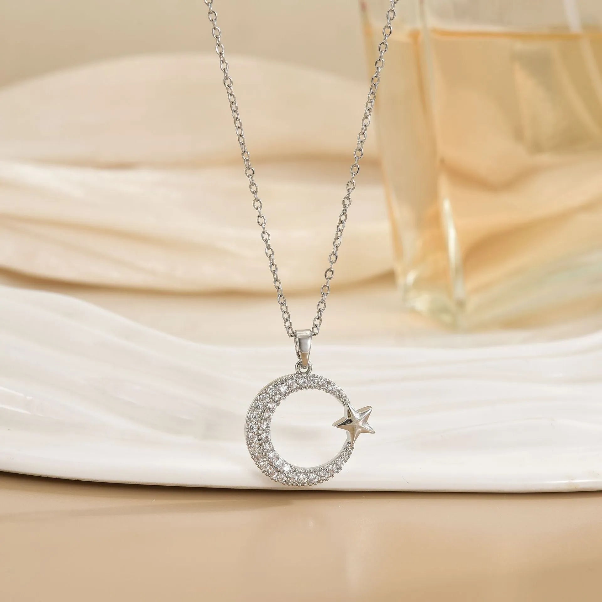 Xingyue gold geometric moon pendant necklace with zircon stone on titanium steel O-ring chain against white background