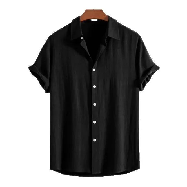 A man wearing a loose fit black short sleeve casual cardigan shirt on a beach.