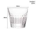 Clear crystal whiskey shot glass with a thick bottom on a wooden surface.