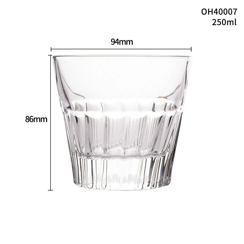 Clear crystal whiskey shot glass with a thick bottom on a wooden surface.