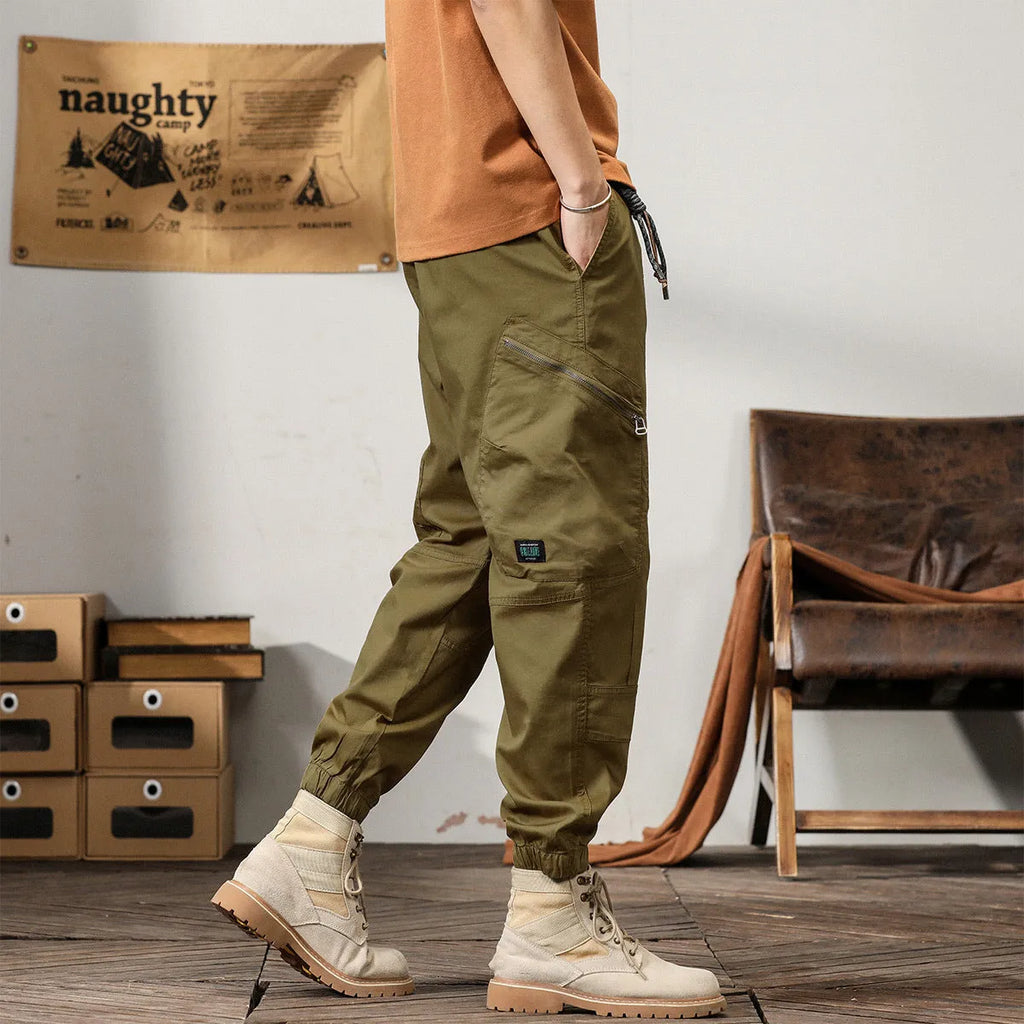 Men's khaki cotton harem pants with tapered leg and ankle band on a mannequin.