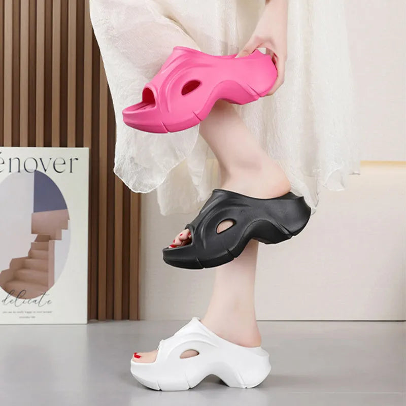 Women's white thick-soled EVA slippers with round toe on a beach background.