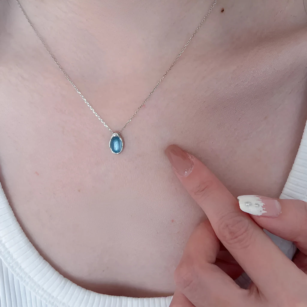 Geometric navy blue water drop pendant necklace on an adjustable copper chain.