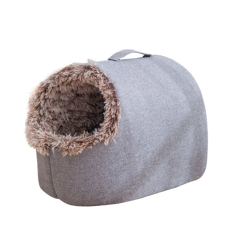 Grey fleece-lined closed cat sleeping bag with portable handle on brown floor
