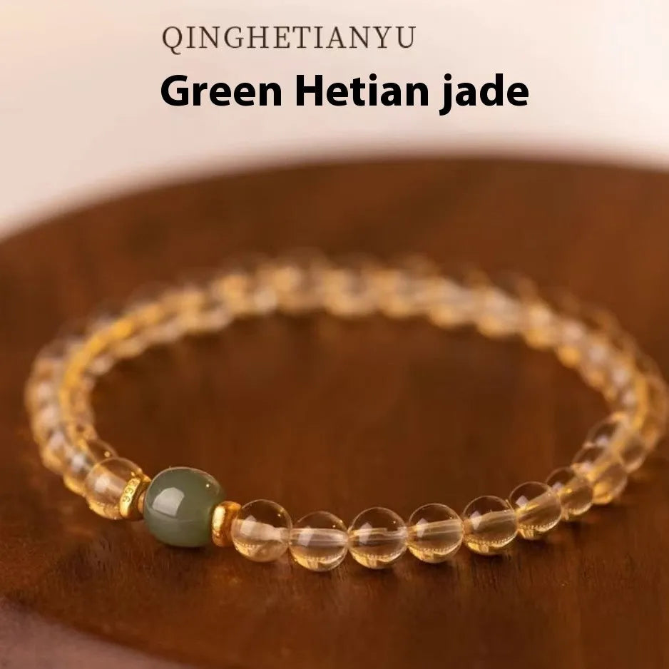 Handmade natural rutilated quartz bracelet with golden needles on wrist, showing 8mm beads.