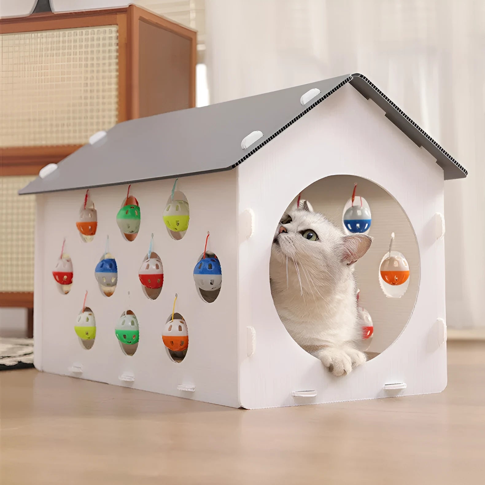 Plastic integrated cat scratch board, nest bed, and tunnel toy with a bell.