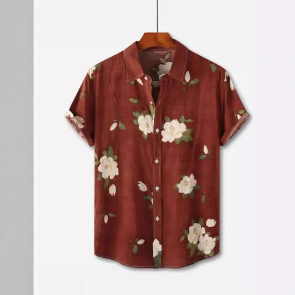 Man's short sleeve Hawaiian print shirt with lapel collar and floral pattern, shown in a casual setting.