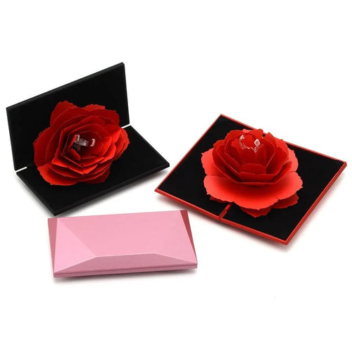 Red plastic heart-shaped rotating ring box with rose decoration inside white storage case