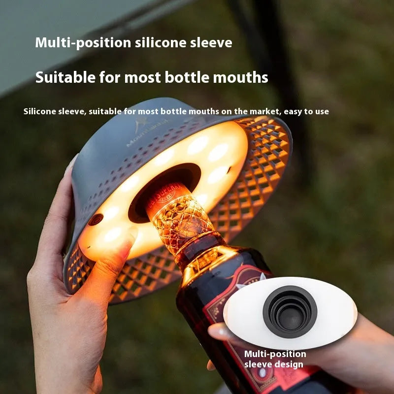 Beige and grey wine bottle-shaped camping lantern showing its compact size and light gear switch.