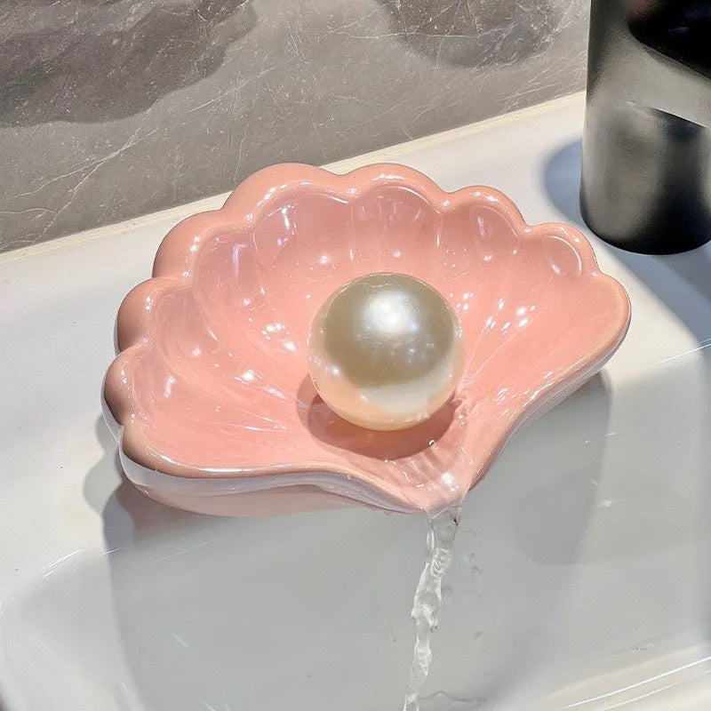 White shell-shaped plastic soap dish for bathroom countertop.
