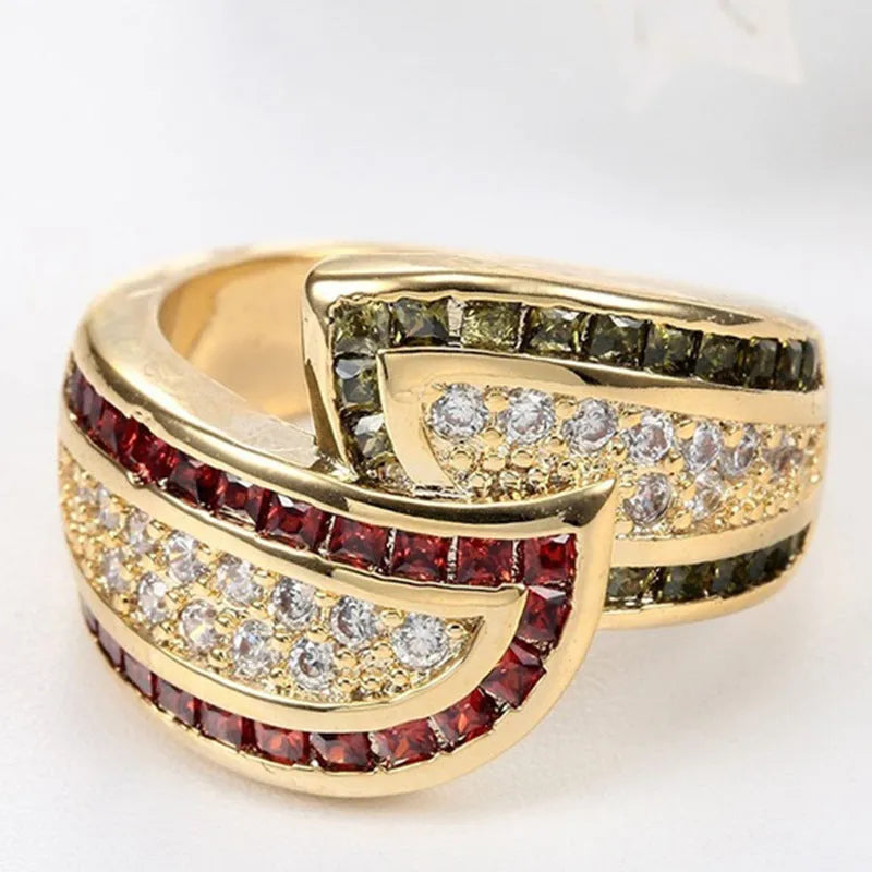 Gold women's ring with green peridot stone on finger, showing metallic finish and stone detail